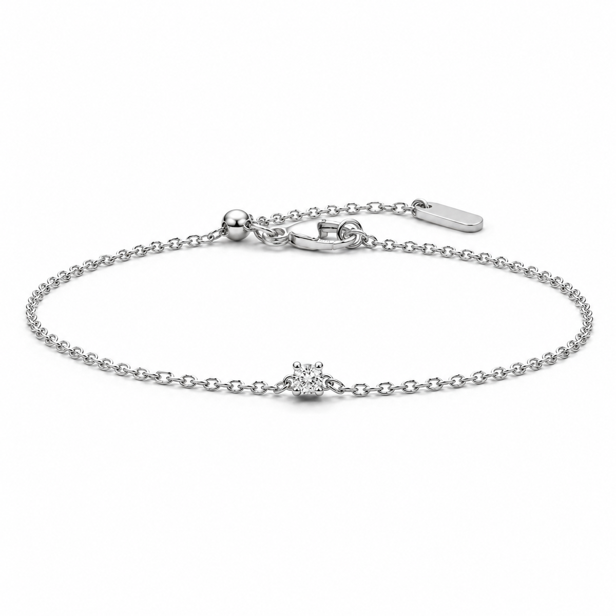 A delicate silver chain bracelet with a small central floral cluster charm, photographed on a clean white background.