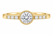 A yellow gold ring featuring a large round brilliant-cut center stone in a beaded halo setting, with smaller round stones set along the shoulders, shown on a plain white background.