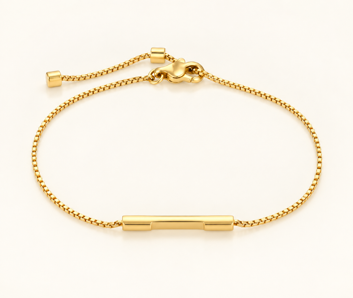 A gold chain bracelet with a polished horizontal bar centerpiece and adjustable sliding clasp, photographed on a clean white background.