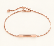 A rose gold chain bracelet with a polished horizontal bar at the center and an adjustable sliding clasp, shown on a clean off-white background.