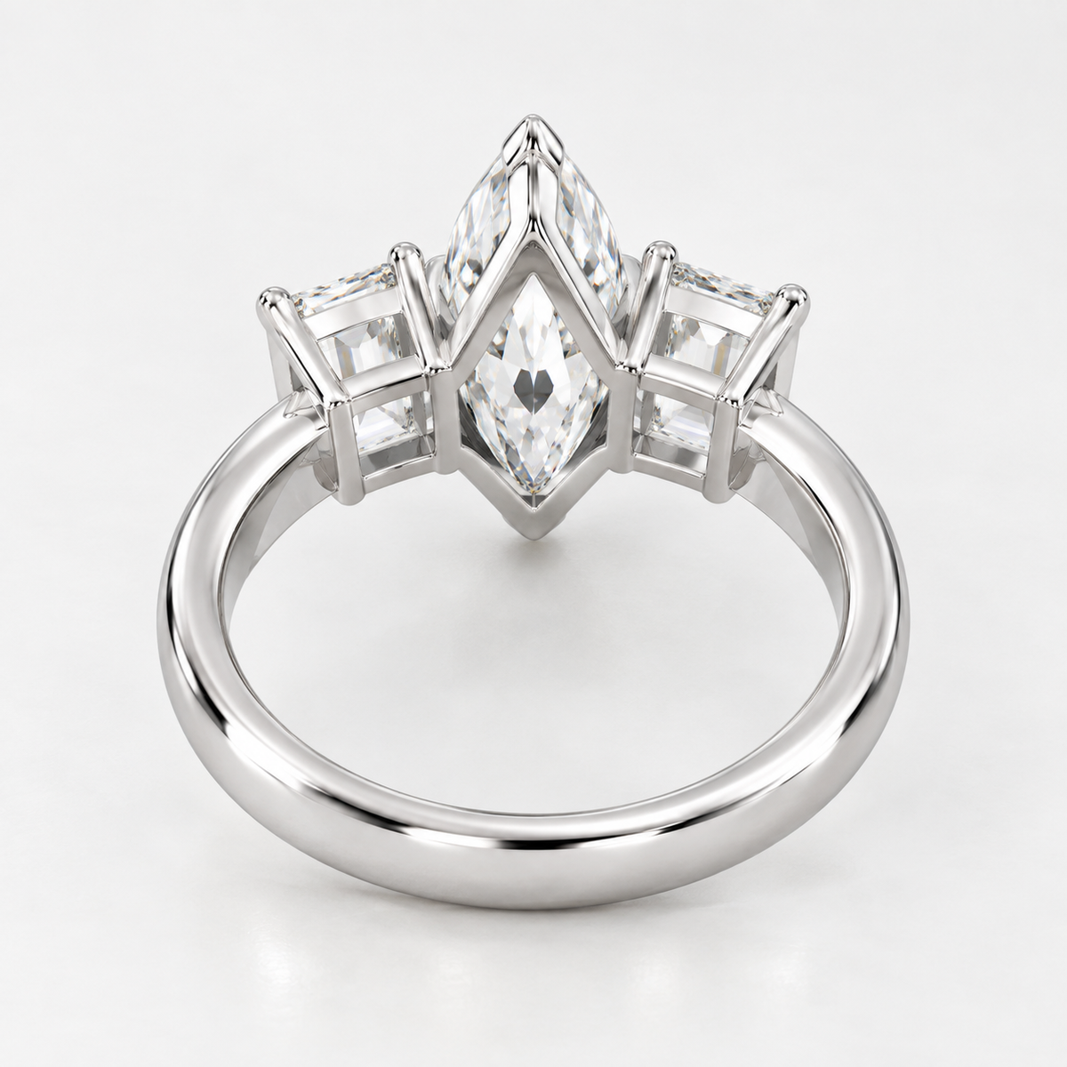 A silver ring featuring a marquise-cut center stone and three baguette-cut side stones, set in a polished silver band on a light gray background.