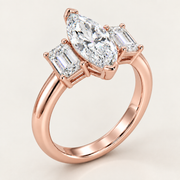 Rose gold ring featuring a marquise-cut center diamond flanked by two baguette-cut diamonds, set on a polished band against a light beige background.