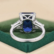 Emerald cut blue sapphire engagement ring with moissanite side stones